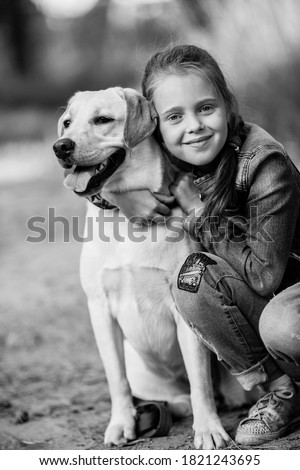 Ten-years-old girl with her dog. Black and white photography.