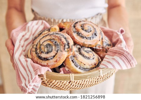 A selective focus shot of delicious poppy seed rolls with a sugar glaze in a basket