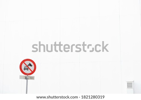No driving sign in front of a white wall with a vent
