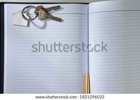 house shaped key ring on the blank book    