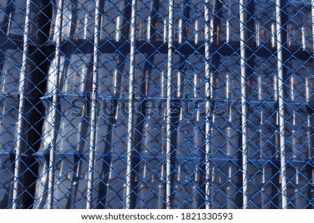 Blue metal mesh on the background of glass bottles in packaging. Close-up. Background.