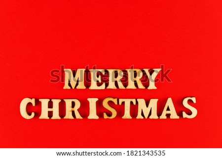 wooden letters on red background. Merry christmas lettering in red paper. Copy space.