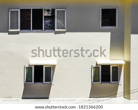 Wall of a house under construction with open windows.