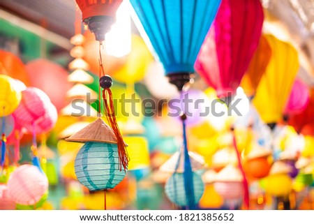Decorated colorful lanterns hanging on a stand in the streets of Cholon in Ho Chi Minh City, Vietnam during Mid Autumn Festival. Chinese language in photos mean money and happiness. Selective focus.