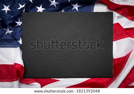 Blank slate board over American flag as a concept for US national celebrations
