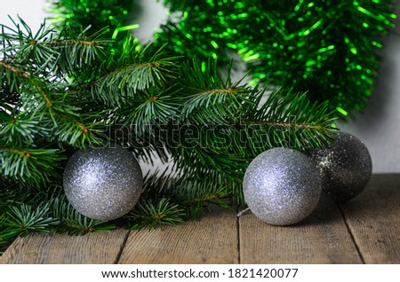 Spruce branches with green needles and Christmas balls on a wooden background. Selective focus.