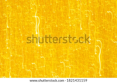 Abstract glitter golden glowing sparkling shiny background. Holiday gold wrapping paper texture. Christmas holiday seasonal wallpaper decoration. Greeting and wedding invitation card design template.