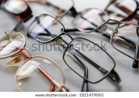 A display of prescription eye glasses in different styles and designs isolated with a white background. Royalty-Free Stock Photo #1821459065