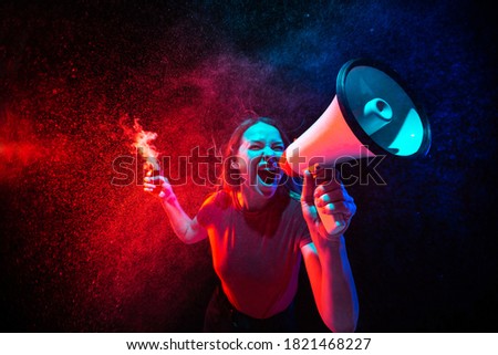 Young woman with smoke and neon light on black background. Highly tensioned, wide angle, fish eye view. Concept of human emotions, facial expression, sales, ad, sport.
