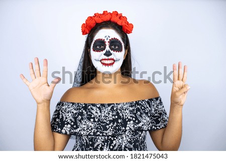Woman wearing day of the dead costume over isolated white background showing and pointing up with fingers number eight while smiling confident and happy