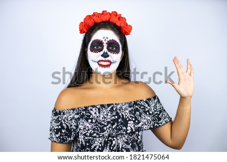 Woman wearing day of the dead costume over isolated white background doing hand symbol