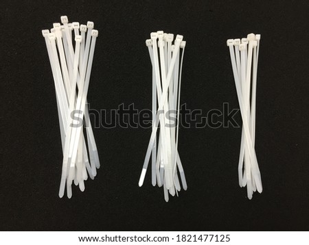White nylon cable tie isolated on a black background