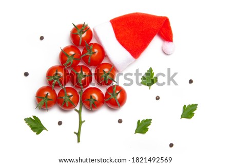 Cherry tomato Christmas tree and Santa hat on white background. 