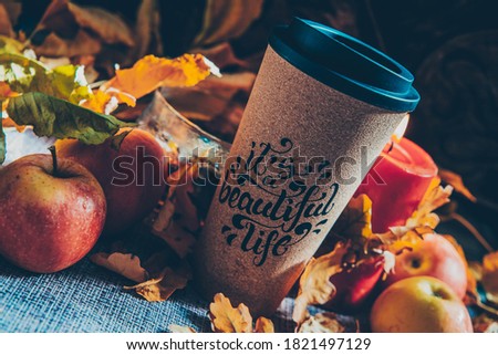 Autumn picture with yellow dry leaves and a glass of coffee