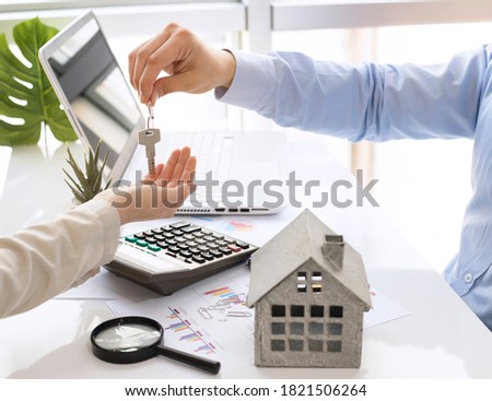 real estate agent man giving house keys and sign deal in office
