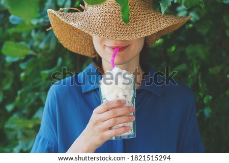 smiling young woman holding glass full of sugar cubes with a straw, hidden sugar in drinks concept, risk of diabetes Royalty-Free Stock Photo #1821515294
