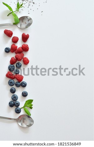 Summer layout made with juicy ripe berries of blueberries and raspberries on a white background.Summer mood. Copy space. Selective focus. Flat lay