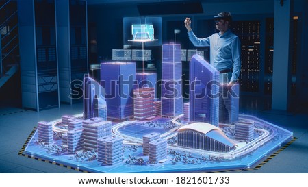 Industry 4.0: Modern Professional Architect Wearing Virtual Reality Headset Uses Gestures to Design, Manipulate Buildings for 3D City. Mixed Augmented Reality Software. VFX Special Visual Effect Royalty-Free Stock Photo #1821601733