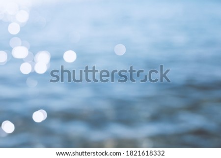 Delicate blue texture bokeh sea background. blurry blue bokeh glare on the water on a sunny day. rest and travel