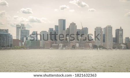 A hazy downtown Boston skyline, from the middle of the harbor.