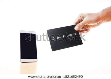 A smartphone and a cropped hand holding a black card with message on online payment on white background 