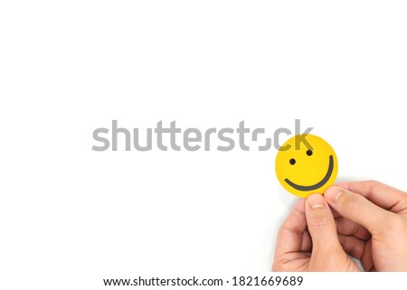 Happiness and positivity concept. Peeking yellow smiling happy face in white background with copy space.