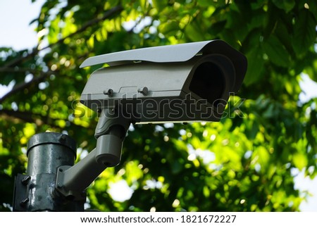 Selective focused, CC.TV. camera installed on metal pole in public park to monitor, record safety security incident for evidence of crime scene. Concept CC.TV. security.                             