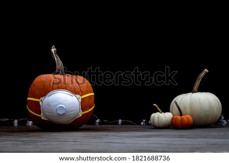 Halloween Pumpkin on wood board with medical N95 mask dark background copy space
