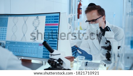 Scientist working with microscope in futuristic laboratory. Genetic research Royalty-Free Stock Photo #1821710921