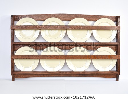 Antique quarter sawn oak plate rack with white china plates Royalty-Free Stock Photo #1821712460