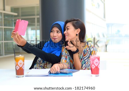 young beautiful muslim woman taking a self portrait with camera phone