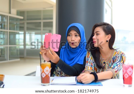 young beautiful muslim woman taking a self portrait with camera phone