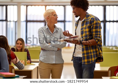 Male student at the lecture asking professor for some explanations about the lesson Royalty-Free Stock Photo #1821749954