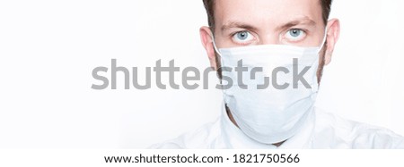 Man in shirt, tie and medical mask looks into camera, isolated