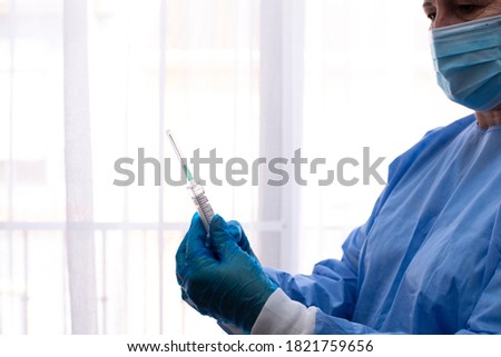Nurse preparing a vaccine for the patient. Selective focus on the syringe. Nurse without focus.
