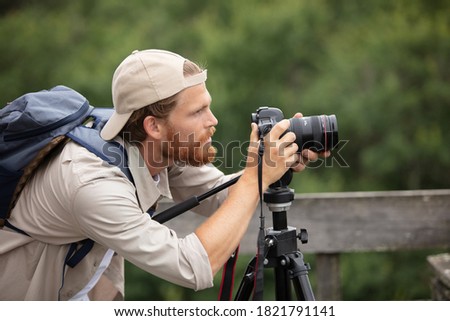 closeup of young hipster man with digital camera outdoors