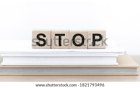 Four wooden cubes with word STOP on table
