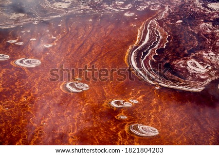 Africa, Tanzania, Aerial view of patterns of red algae and salt formations in shallow salt waters of Lake Natron Royalty-Free Stock Photo #1821804203