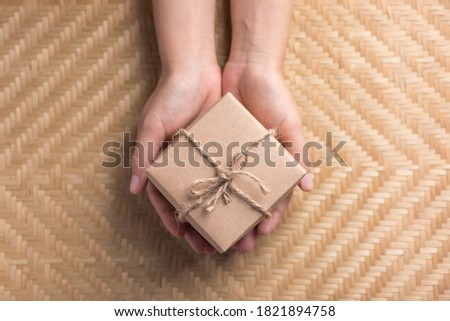 Eco friendly brown paper gift box for giving in special day holding by hand, Top view