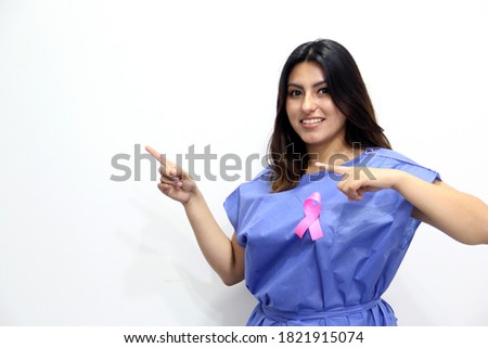 Latin woman disposable blue surgical gown and pink ribbon for campaign against breast cancer