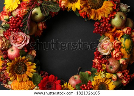 Beautiful autumnal wreath with flowers, berries and fruits on black background, closeup. Space for text