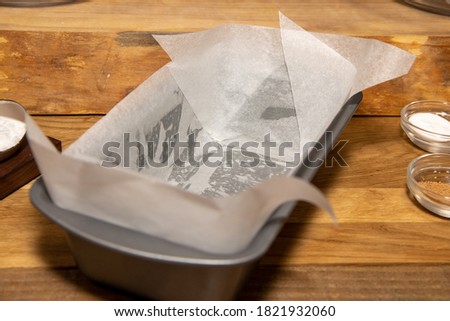 A metal trey with grease proof paper on the kitchen worktop ready to be put in the oven Royalty-Free Stock Photo #1821932060