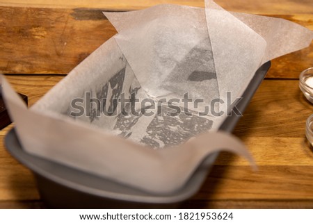 A metal trey with grease proof paper on the kitchen worktop ready to be put in the oven Royalty-Free Stock Photo #1821953624