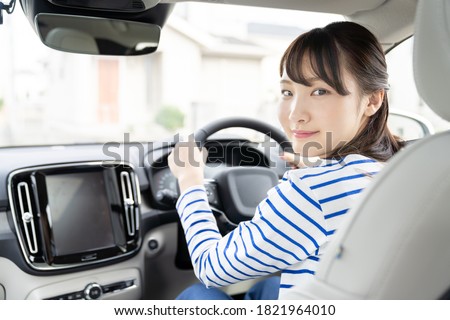 Young asian woman driving a car. Royalty-Free Stock Photo #1821964010
