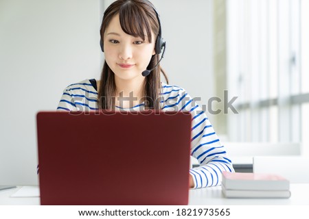 Asian female student taking online class. e-learning. Remote work. Royalty-Free Stock Photo #1821973565