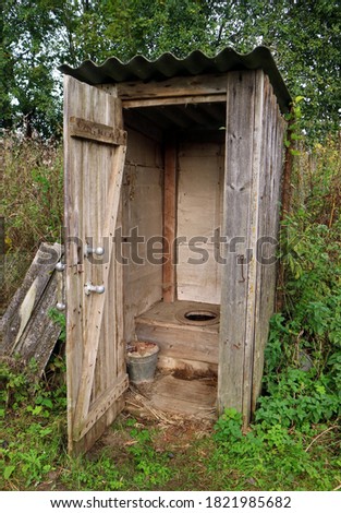 Primitive outdoor wooden toilet  with an open door Royalty-Free Stock Photo #1821985682
