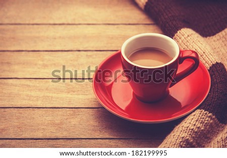 Little and empty white cup for a coffee or tea on a wooden table