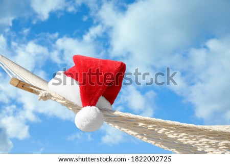 Rope hammock with Santa's hat outdoors, closeup. Christmas vacation