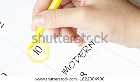 hand encircles a date on a calendar with text modern yellow felt-tip pen