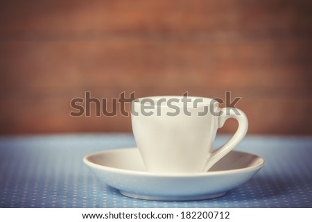 Cup of a coffee on polka dot cover. Photo in old color image style.